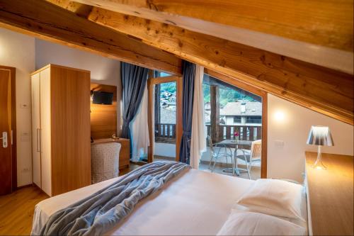 een slaapkamer met een groot bed en een balkon bij Palazzo Lodron Bertelli. Dimora Storica & Spa in Caderzone