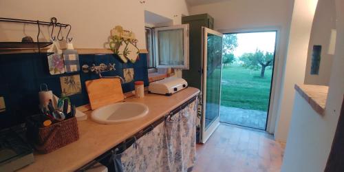 La salle de bains est pourvue d'un comptoir avec lavabo et d'une fenêtre. dans l'établissement Agriturismo Mondomini, à Campofilone