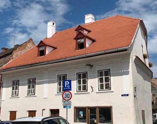 a white building with a red roof on a street at Luna Homes in Sibiu