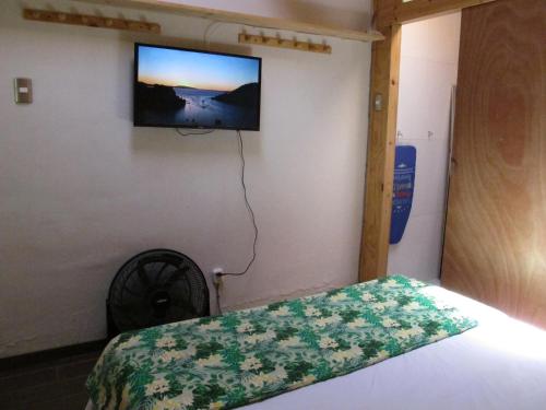 a bedroom with a bed with a television on the wall at Cabañas Lemupewen Chillán 2 in Chillán