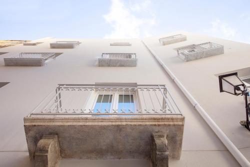 a balcony on the side of a building with windows at Le Cupole Suites & Apartments in Trapani