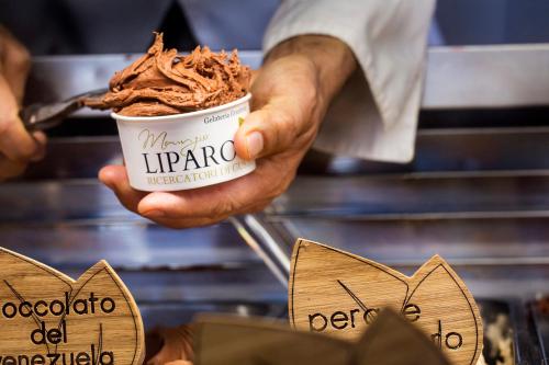 a person holding a cup of chocolate ice cream at Le Cupole Suites & Apartments in Trapani