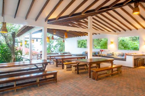
a dining area with tables, chairs, and umbrellas at Mundo Nuevo Eco Lodge in Minca
