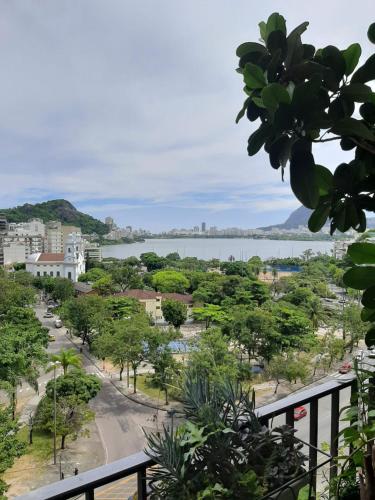 einen Blick von einem Balkon auf eine Stadt und einen Wasserkörper in der Unterkunft Cantinho familiar-Humaitá - somente mulheres - just women in Rio de Janeiro