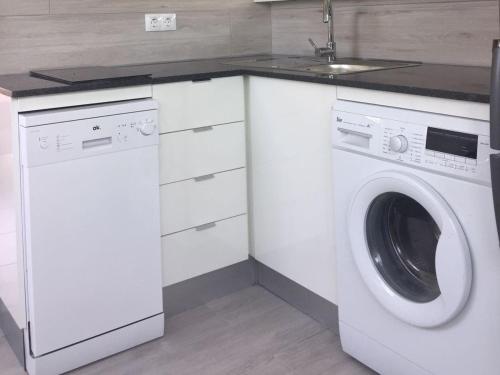 a kitchen with a washing machine and a sink at Playa Del Ingles in Playa del Ingles