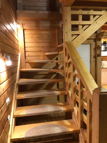 a staircase in a log cabin with wooden treads at Садиба Ванда in Oryavchyk