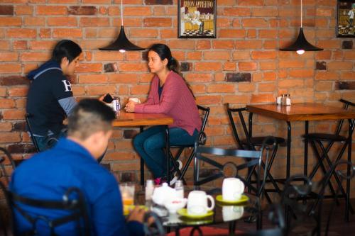 twee mensen aan een tafel in een restaurant bij Hostal Capri in Quito