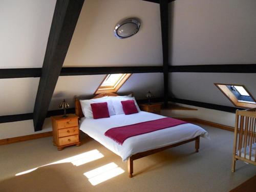 - une chambre avec un lit dans une pièce dotée de fenêtres dans l'établissement Swallows Nest Stanbury Wharf, à Holsworthy