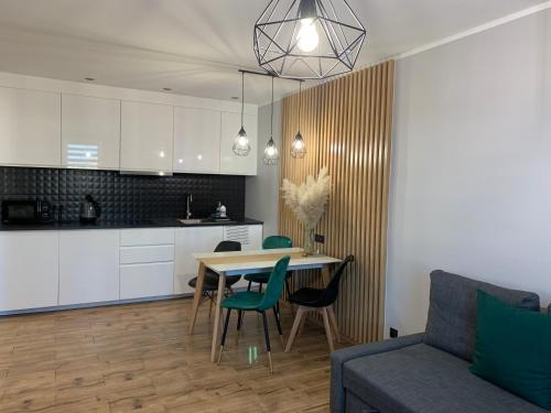 赫爾的住宿－ApartamentLeśna12Hel，厨房以及带桌子和沙发的用餐室。