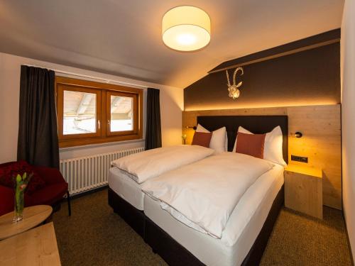 a hotel room with a large bed and a large window at Hotel Parsenn in Davos