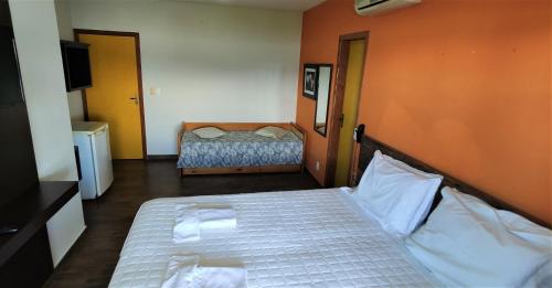 a small bedroom with a bed and a television at Pousada Ecomar in Florianópolis