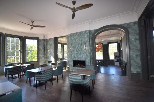 a restaurant with tables and chairs and a fireplace at Lincombe Hall Hotel & Spa - Just for Adults in Torquay