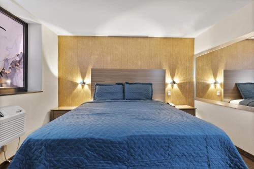 a bedroom with a blue bed with blue pillows at Casa Blanca Hotel Brooklyn Downtown in Brooklyn