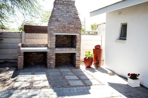 a brick fireplace in the backyard of a house at Aangenaam in Beaufort West