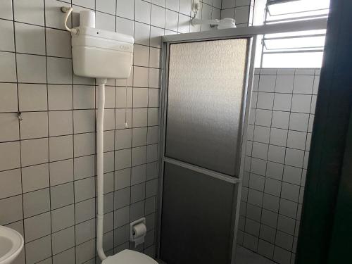 a bathroom with a shower with a toilet and a sink at Hotel Bavarium in Joinville