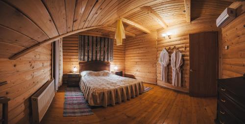 a bedroom in a log cabin with a bed in it at Sanatoriy Karpatia in Shaian