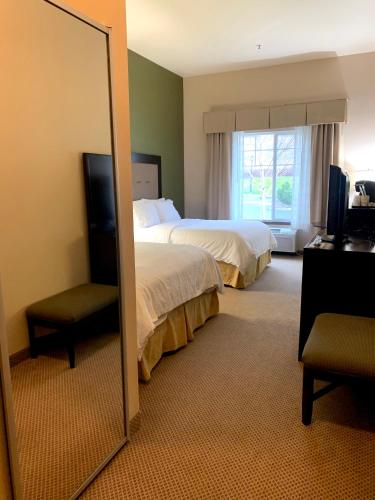 a hotel room with two beds and a mirror at Holiday Inn Express Hotel & Suites North Sequim by IHG in Sequim