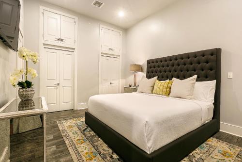 Un dormitorio con una cama grande con cabecero negro. en The Bordeaux, en Nueva Orleans