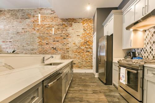 a kitchen with white cabinets and a brick wall at The Bordeaux in New Orleans