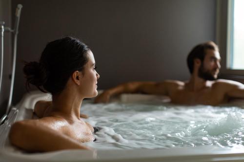 a man and woman in a hot tub at Anusca Palace Hotel in Castel San Pietro Terme