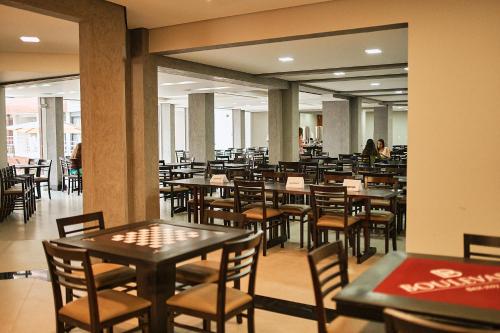 a restaurant with tables and chairs and people in the background at Boulevard Beach Canasvieiras Hotel in Florianópolis