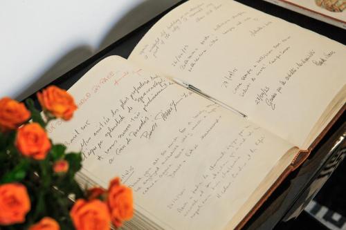 an open book with writing on it next to flowers at Spaccanapoli Comfort Suites in Naples