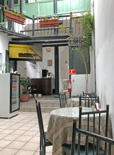 a patio with a table and chairs and a kitchen at Hostal Latina in Cuenca