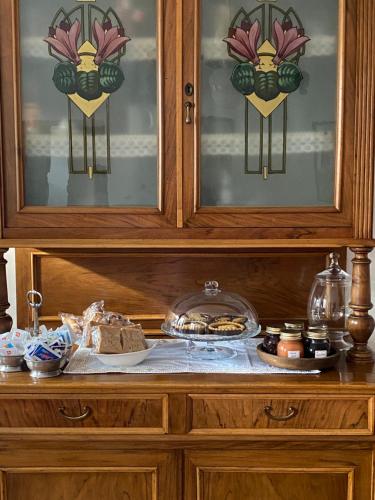 a wooden cabinet with a table with food on it at La casa tra i vigneti in Montecalvo Versiggia