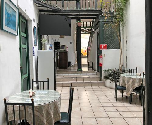a patio with two tables and chairs and a refrigerator at Hostal Latina in Cuenca