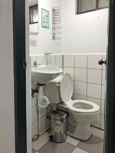 a bathroom with a toilet and a sink at Hostal Latina in Cuenca