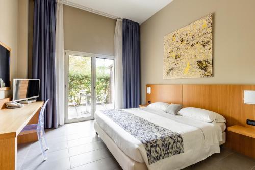 a hotel room with a bed and a window at Anusca Palace Hotel in Castel San Pietro Terme