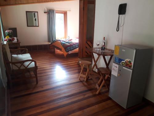 a living room with a refrigerator and a table at Hotel y Spa Isla de Baños in Baños