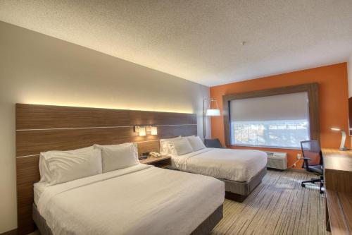 a hotel room with two beds and a window at Holiday Inn Express Hotel & Suites Oshkosh - State Route 41 by IHG in Oshkosh