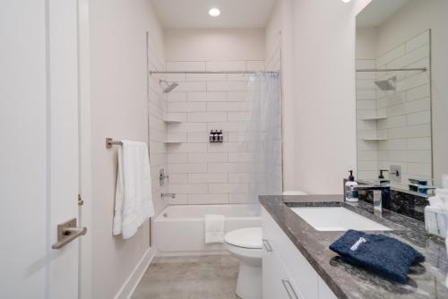 a white bathroom with a sink and a toilet at Mason Lofts at West End in Nashville