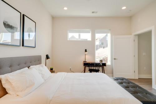 a bedroom with a large white bed and a desk at Mason Lofts at West End in Nashville