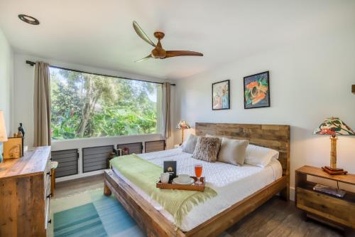 a bedroom with a bed and a large window at Pali Ke Kua #4 in Princeville