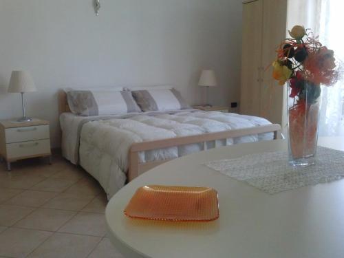 a bedroom with a bed and a table with a vase of flowers at B&B Ore Liete in Martano