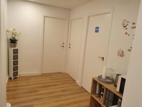 a room with two white doors and a wooden floor at Pensión Muro de la Mata in Logroño