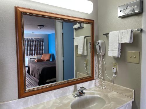 y baño con lavabo y espejo. en Budget Inn Motel en Bourbon