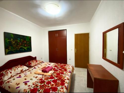 a bedroom with a large bed with flowers on it at Apartmani Vila Marija in Budva