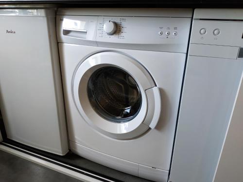 a white washer and dryer sitting on a counter at theApartments Manufaktura in Łódź