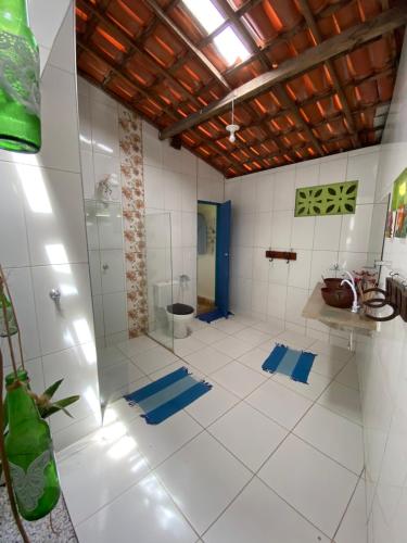 a bathroom with a shower and a toilet at Casa de temporada Arco das Flores in Taíba