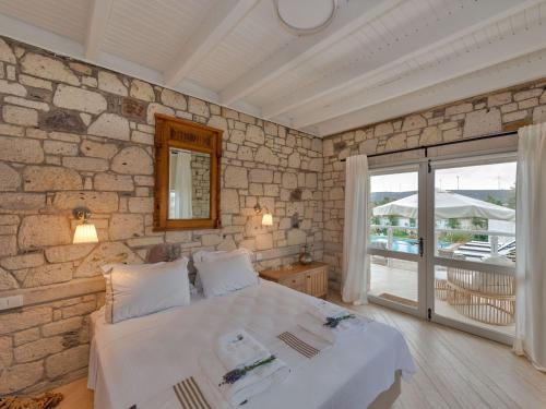 ein Schlafzimmer mit einem Bett und einer Steinwand in der Unterkunft Ev Bharat Butique Hotel, Alaçatı in Alacati