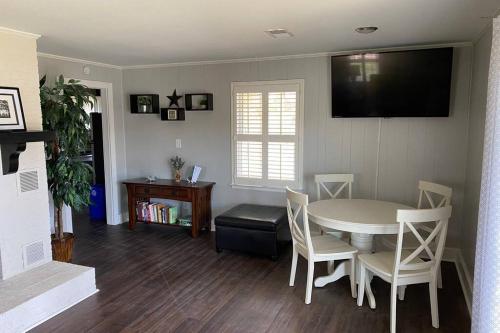 a dining room with a table and chairs and a television at Belmont NC Riverfront 2-Bedroom Garden Suite in Charlotte