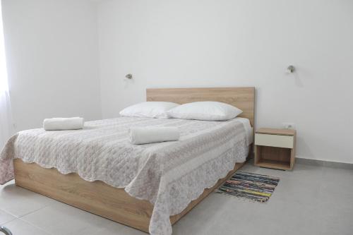 - une chambre dotée d'un grand lit avec des draps et des oreillers blancs dans l'établissement Sandy beach apartments, à Ljubač