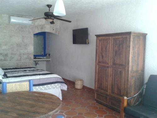 a bedroom with a bed and a table and a ceiling fan at Casa Maru Hotel in Parras de la Fuente