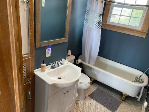 a bathroom with a sink and a tub and a toilet at Uptown Treehouse in New Orleans