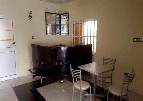 a room with a table and chairs and a piano at BENIN CITY CENTER HOTEL in Cotonou
