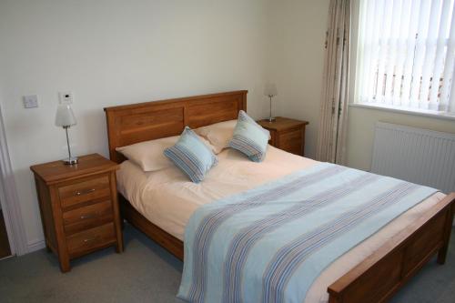 um quarto com uma cama com duas mesas de cabeceira e dois candeeiros em The Priory em Shanklin