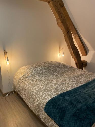 a bedroom with a bed with two lights on it at L épicéa in Mélamare
